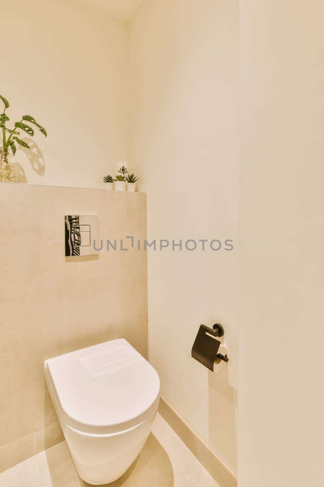 a bathroom with a toilet and plant on the wall next to the toilet in the photo is taken from above