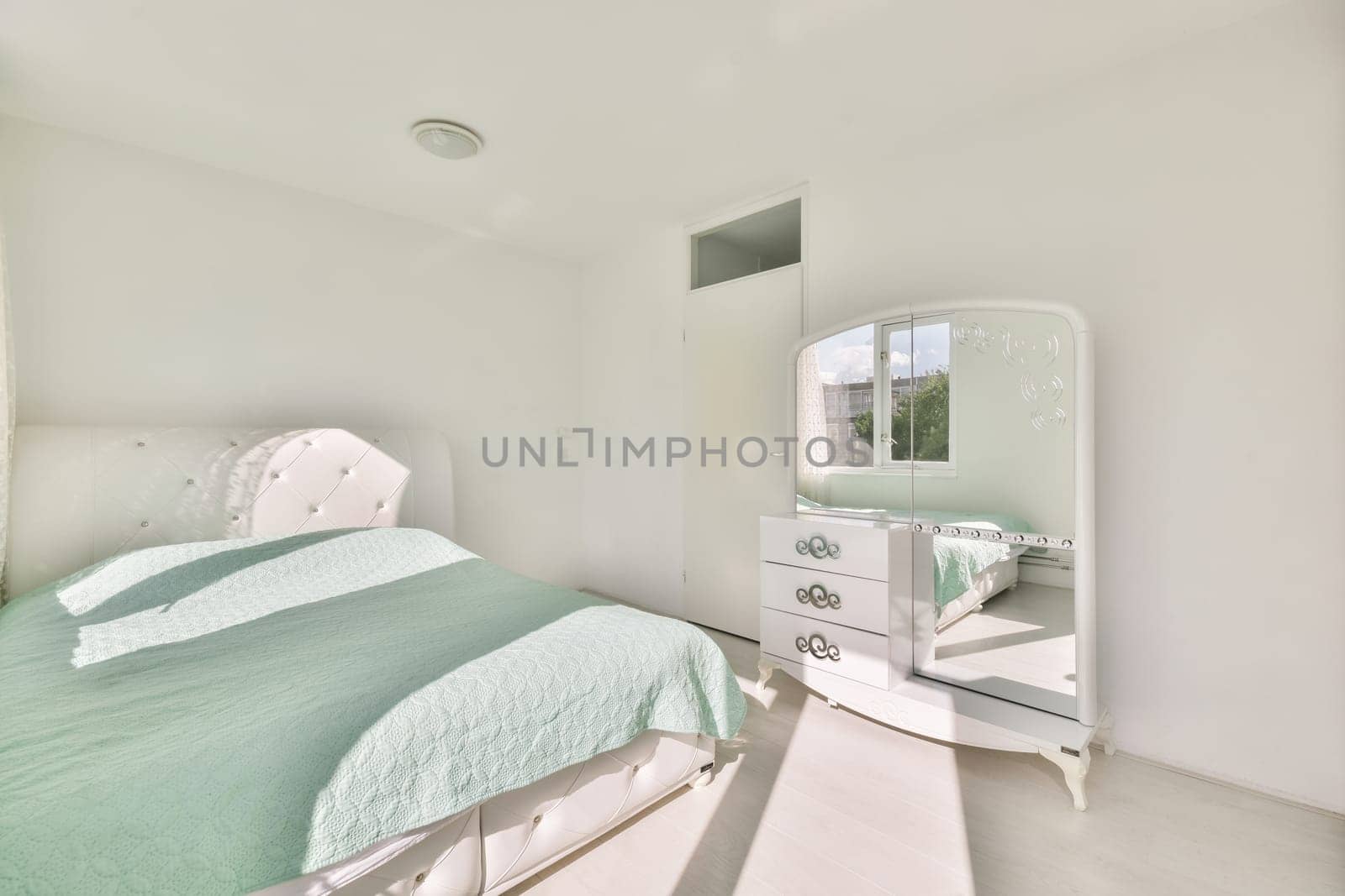 a bedroom with a bed, dresser and mirror on the wall in front of the room is very clean white