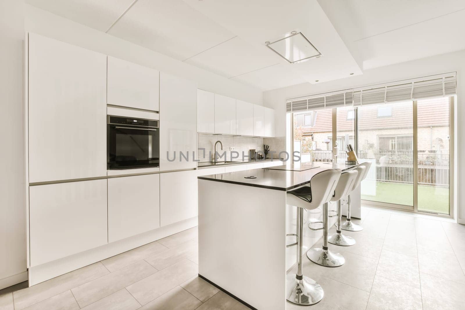 a modern kitchen with white cabinets and appliances in the middle part of the room that is open to the patio