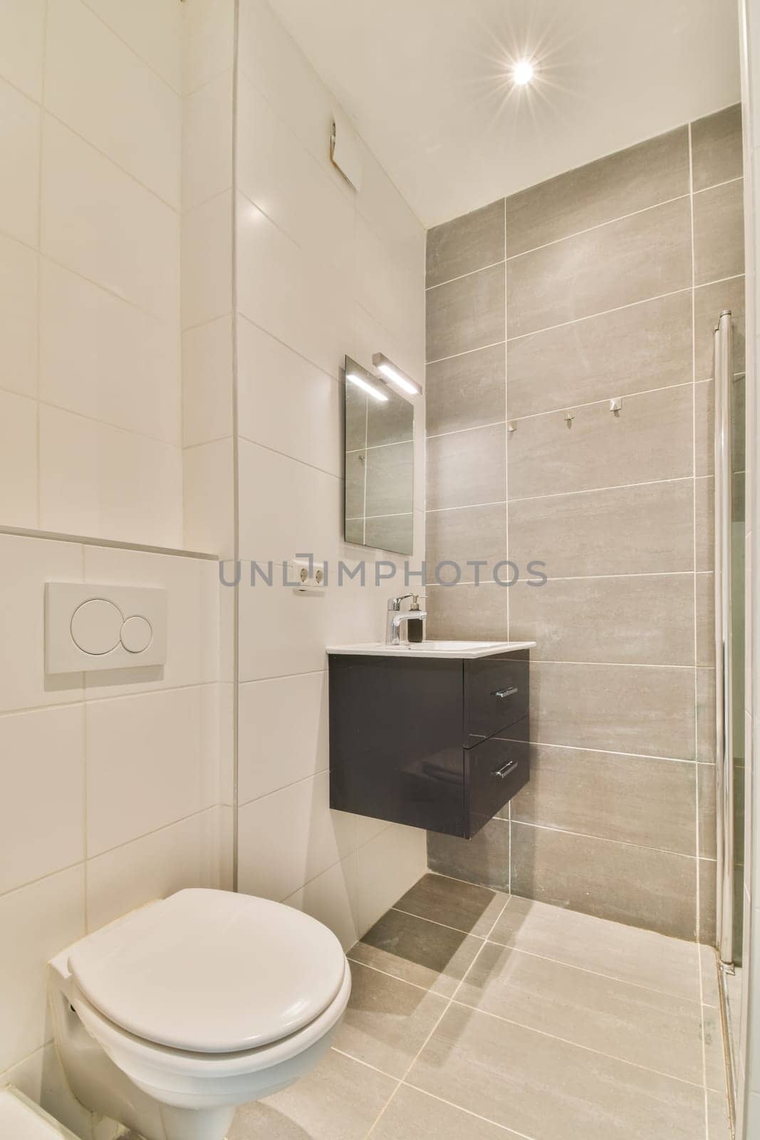 a bathroom with a white toilet and shower stall in the corner next to it is a mirror on the wall