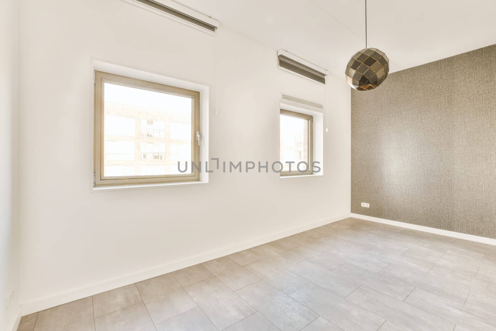 an empty room with white walls and wood flooring, there is a large window in the wall has no light