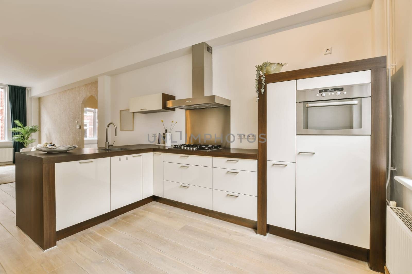 a modern kitchen with white cabinets and wood flooring in the middle part of the image is taken from above