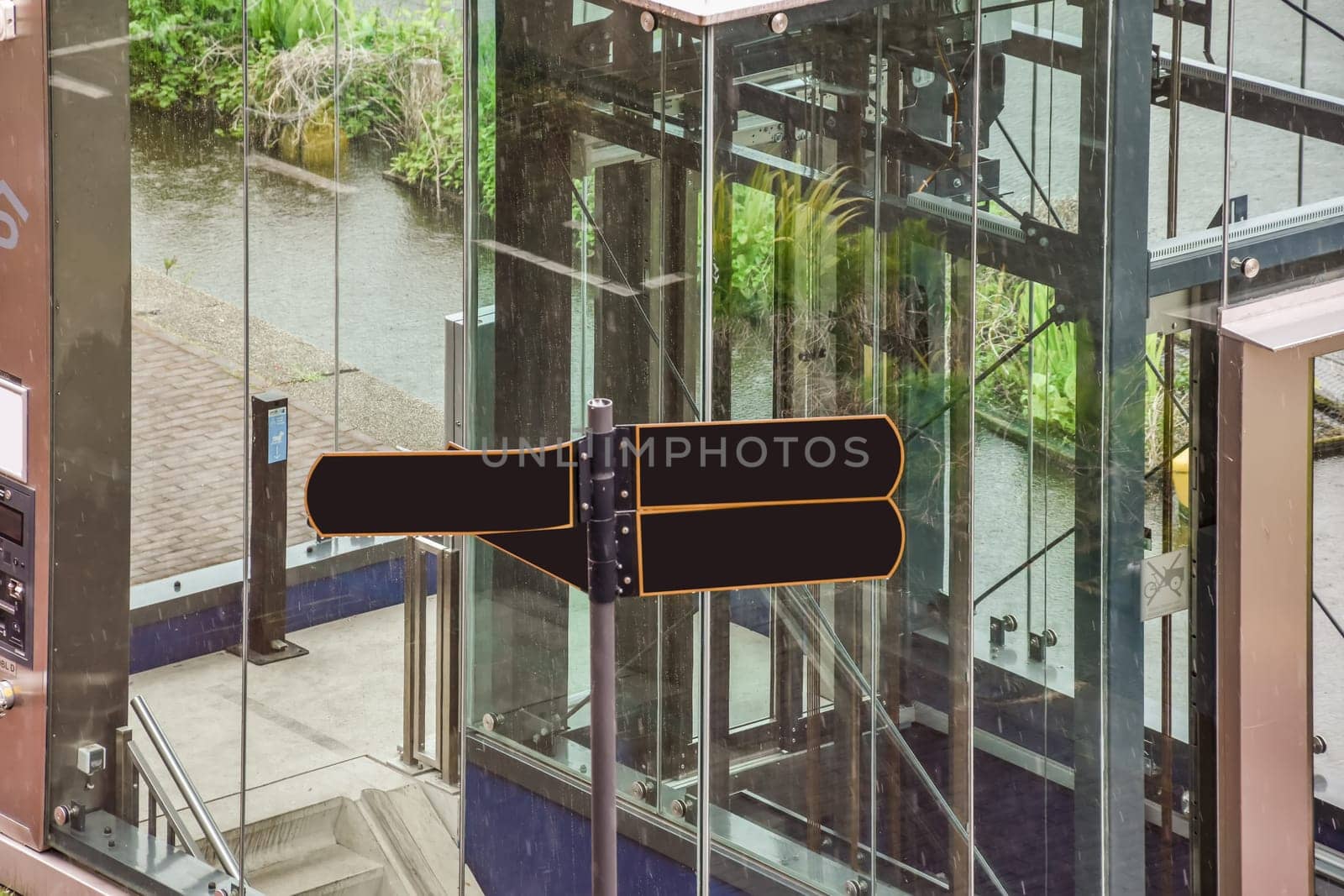 an elevator in the middle of a building with glass doors and railings on either side, there is a view from above