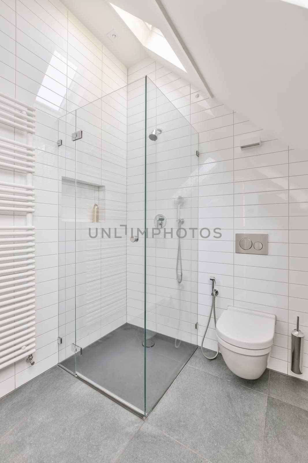 a modern bathroom with white tile walls and flooring, including a glass walk - in shower stall on the right side