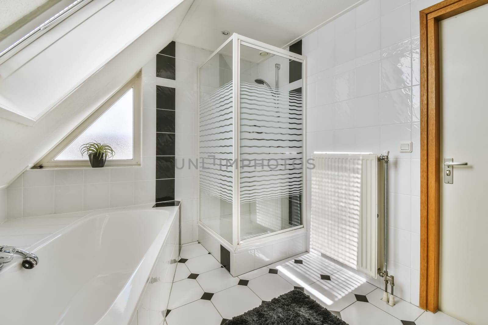 a white bathroom with black and white tiles on the floor, there is a freestanding shower stall in the corner