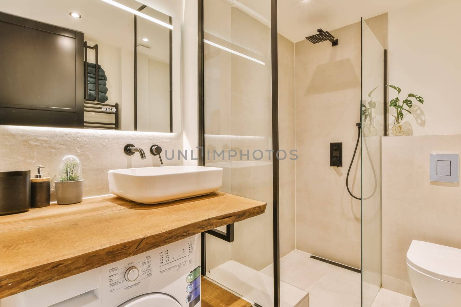a bathroom with a sink, toilet and washer on the counter in front of the shower stall is made out of wood