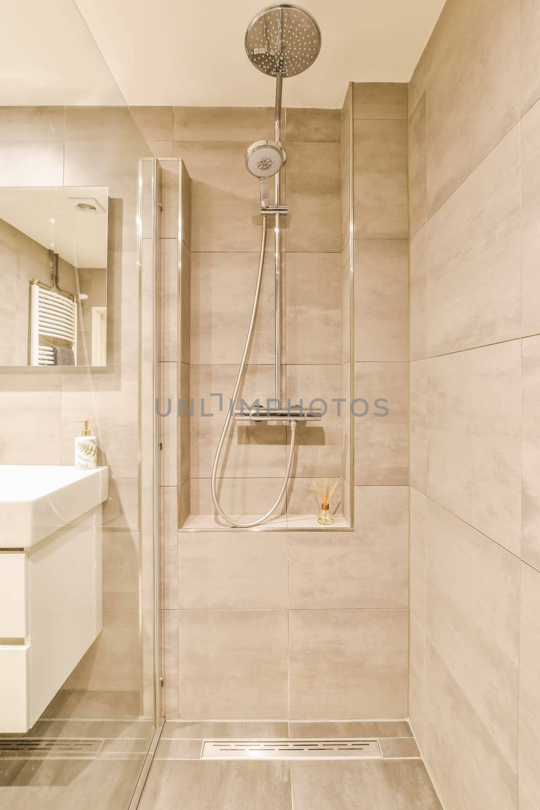 a bathroom with a shower head and hand held in front of the wall, next to a sink that is on the right side