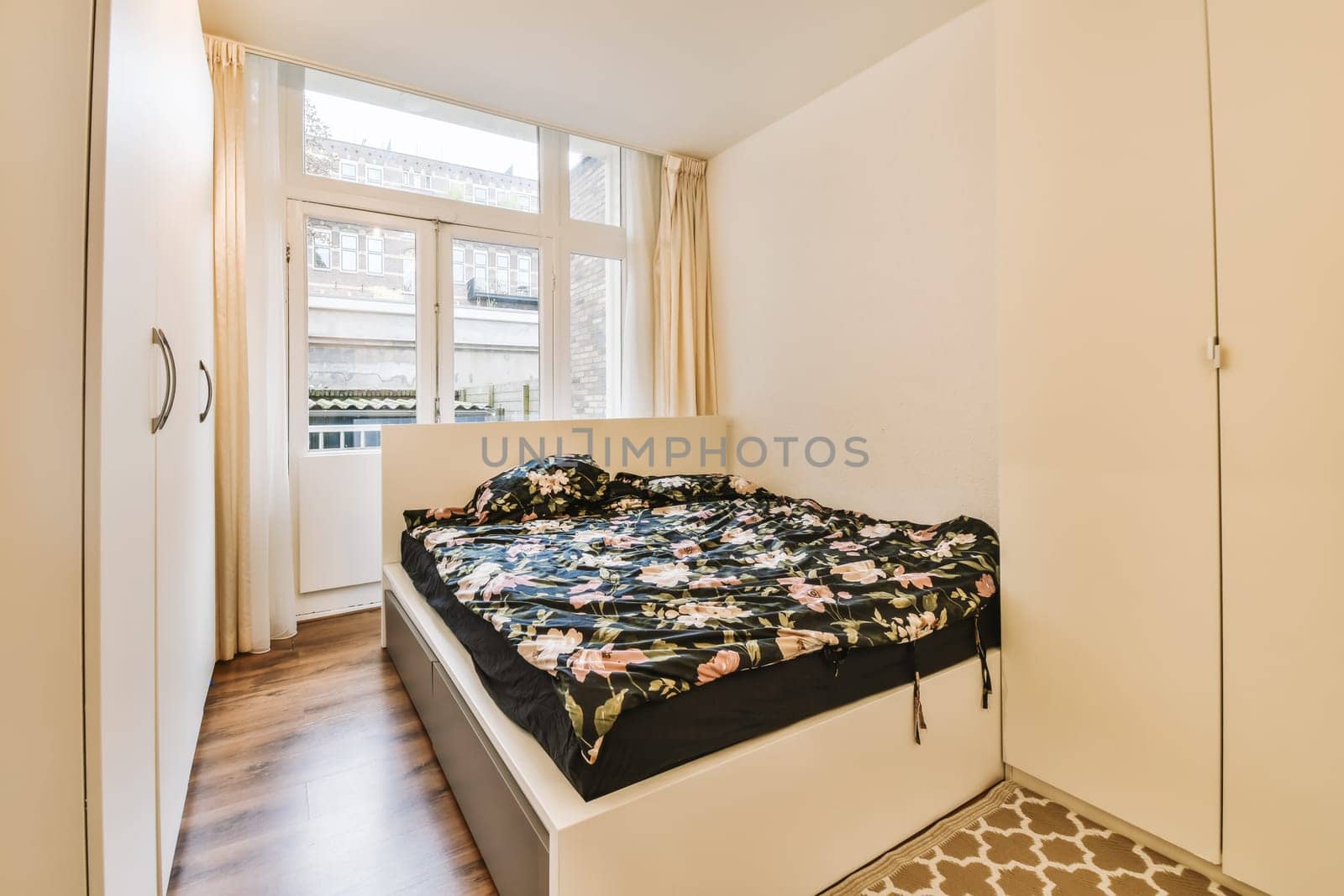 a bedroom with a bed and wardrobes in the corner, there is an open door leading to another room