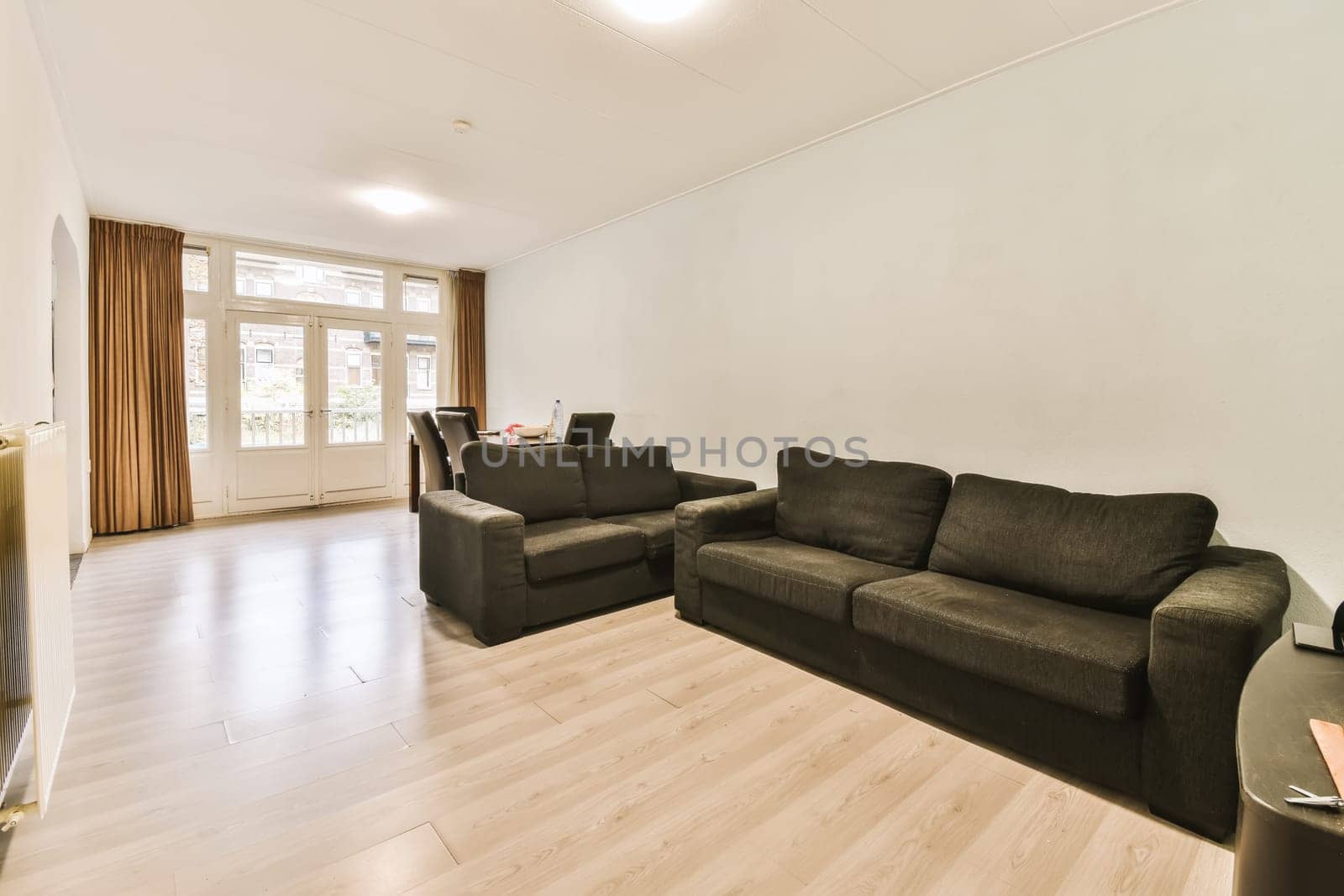 a living room with two couches and a coffee table in the center of the room is white painted walls
