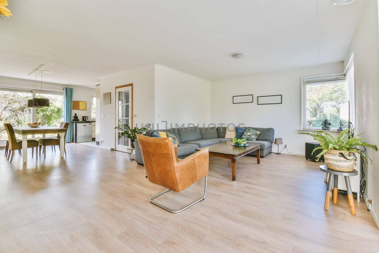 a living room with wood flooring and white walls in the center of the room is a dining table, two chairs and a