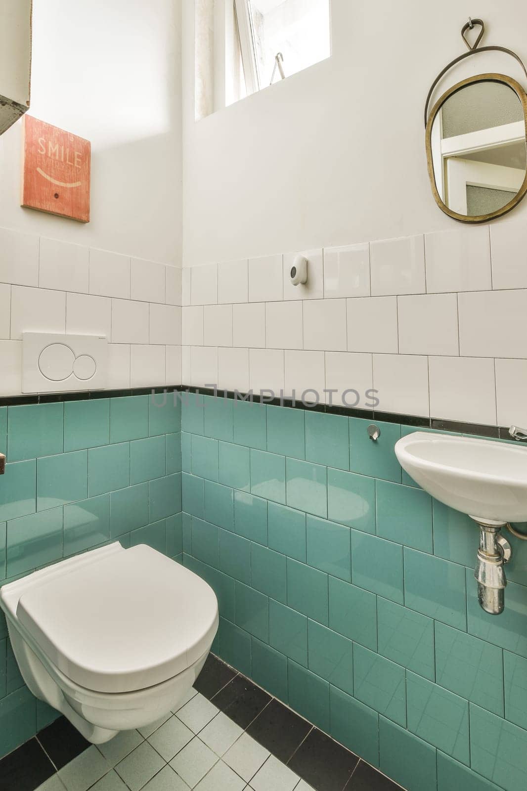 a bathroom with blue tiles on the walls and white fixtures in the toilet bowl is next to the sink basin