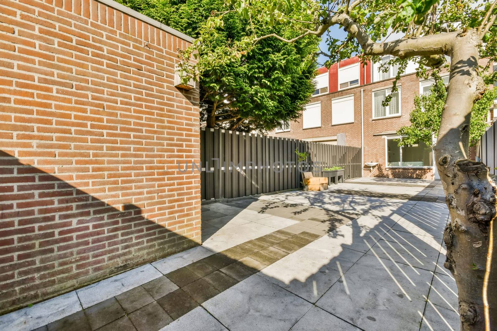 an outside area with brick walls and trees in the fore - image is taken from property listing, not available