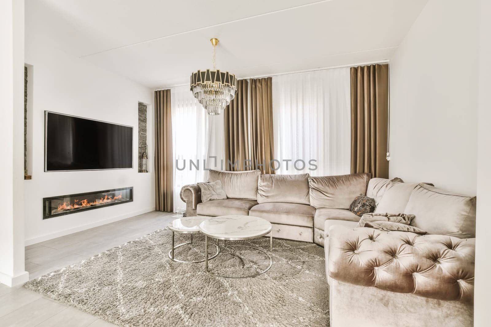 a living room with two couches and a fire place in the center of the room, there is a tv on the wall