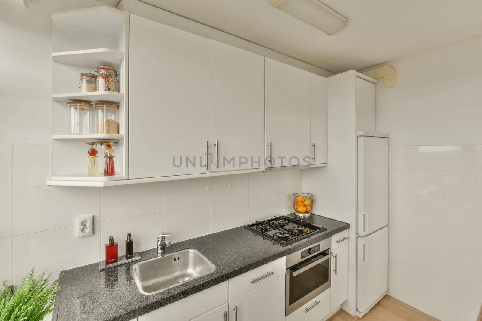 a kitchen with white cabinets and black granite counter tops in the center of the image is an oven, dishwasher, sink
