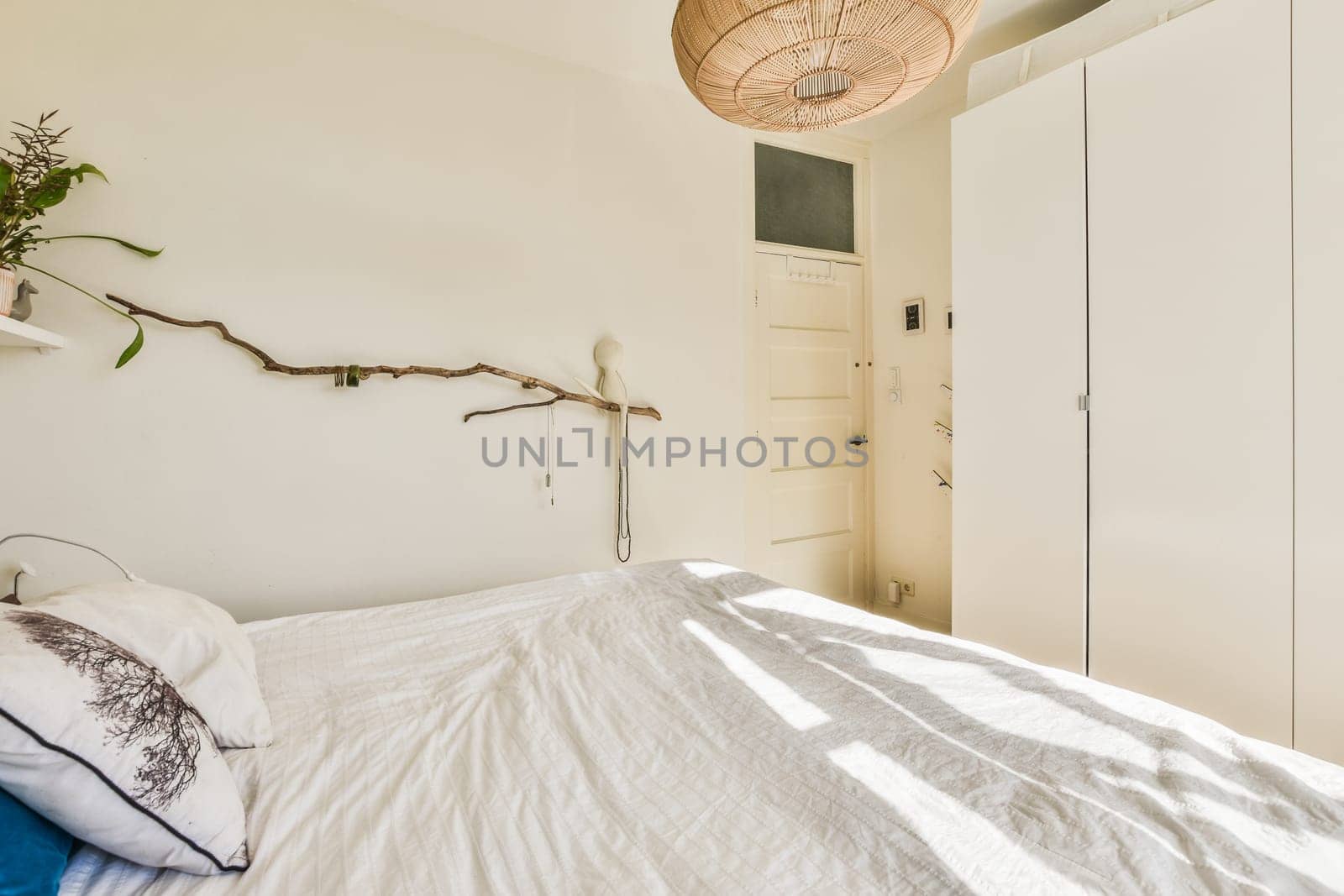 a bedroom with a bed and some plants on the headboards hanging from a ceiling light over the bed