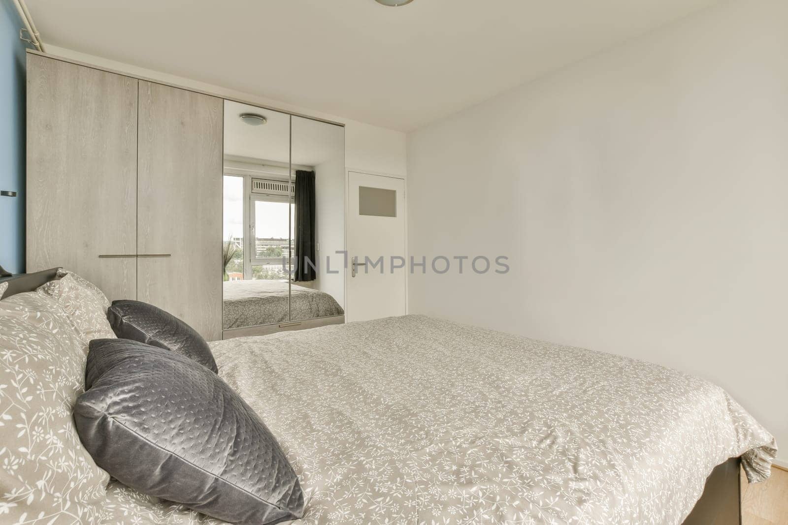 a bedroom with a bed and mirror on the wall next to each other room's closets in it