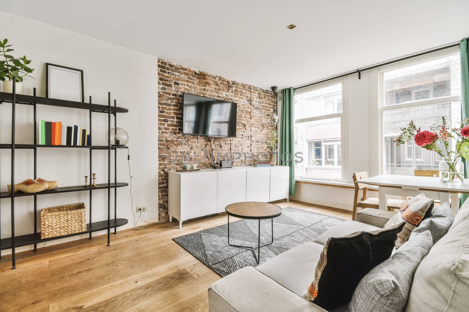 a living room with exposed brick walls and wood flooring in the center of the room is a white sofa