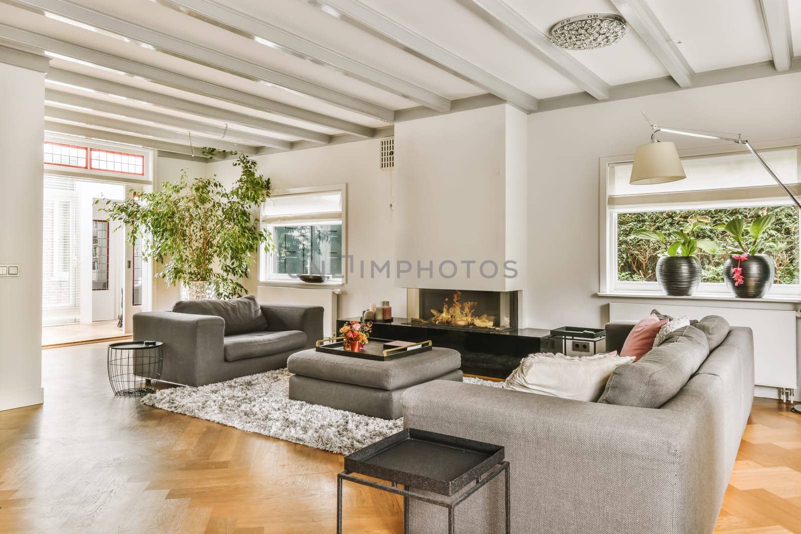 a living room with two couches, a coffee table and a fireplace in the center of the room is surrounded by white walls