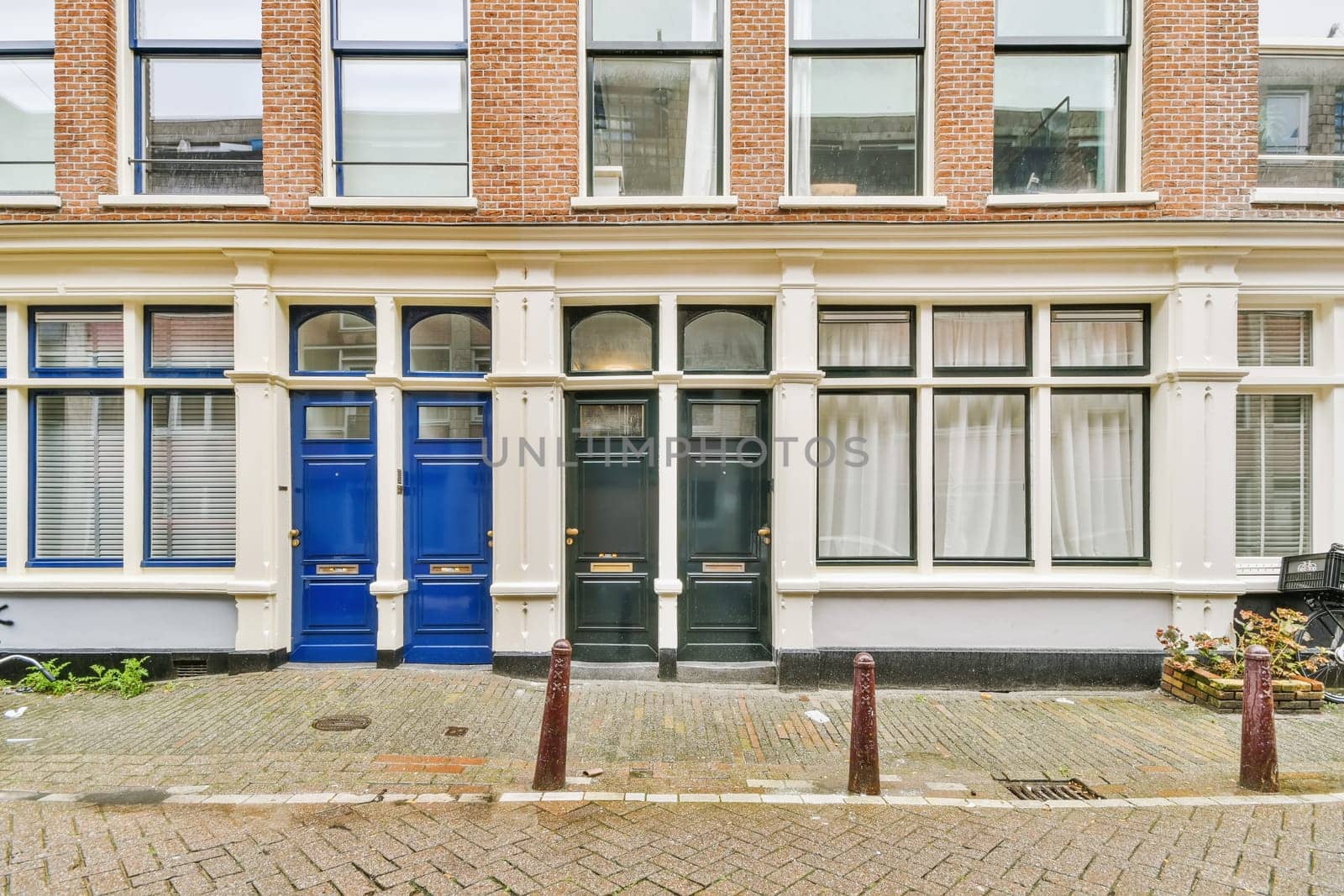 a brick building with blue door and window panes on the outside, in front of a bicycle parked next to it