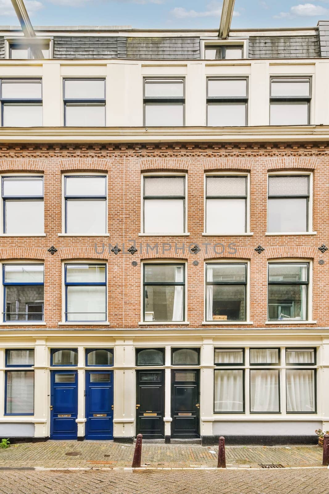 an old brick building in amsterdam, with blue doors on the front and windows open to let you into your home