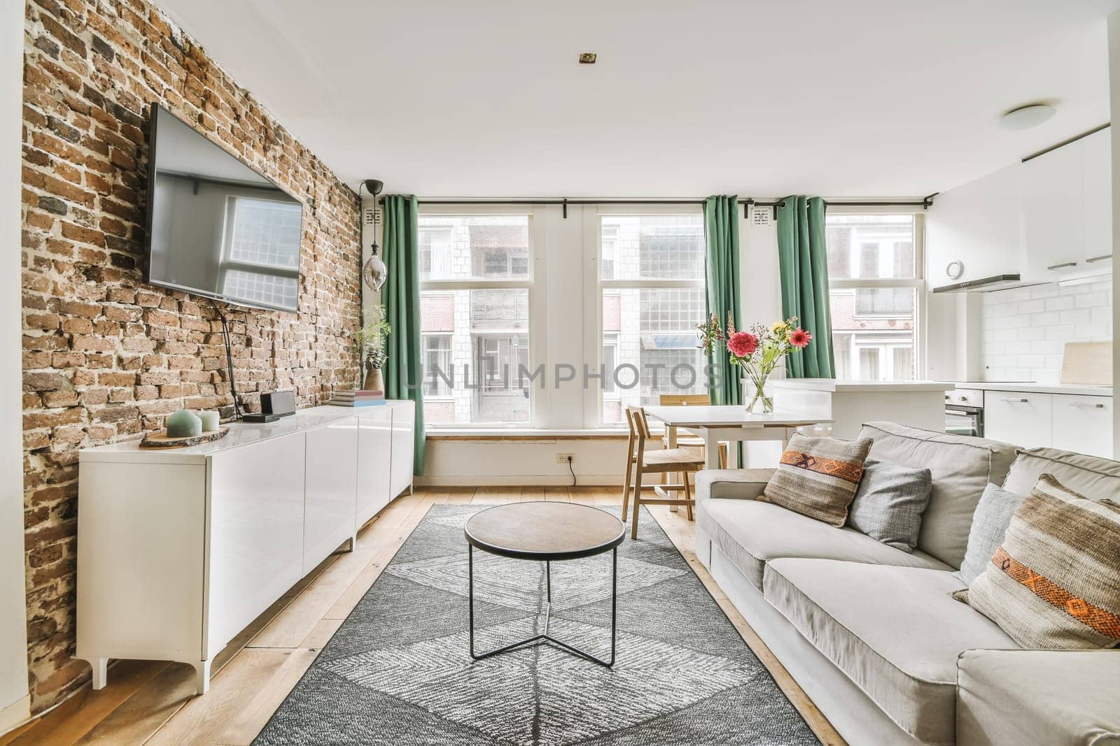 a living room with exposed brick walls and an area rug that has been used as a carpet for the floor