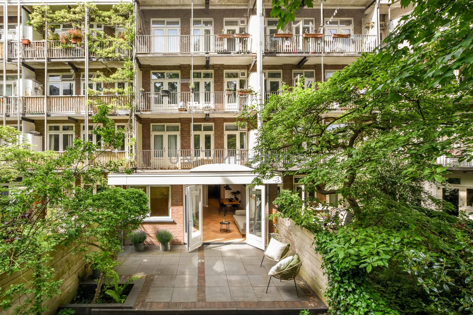 an apartment building with lots of plants and trees in the fore - image is taken from above, looking down