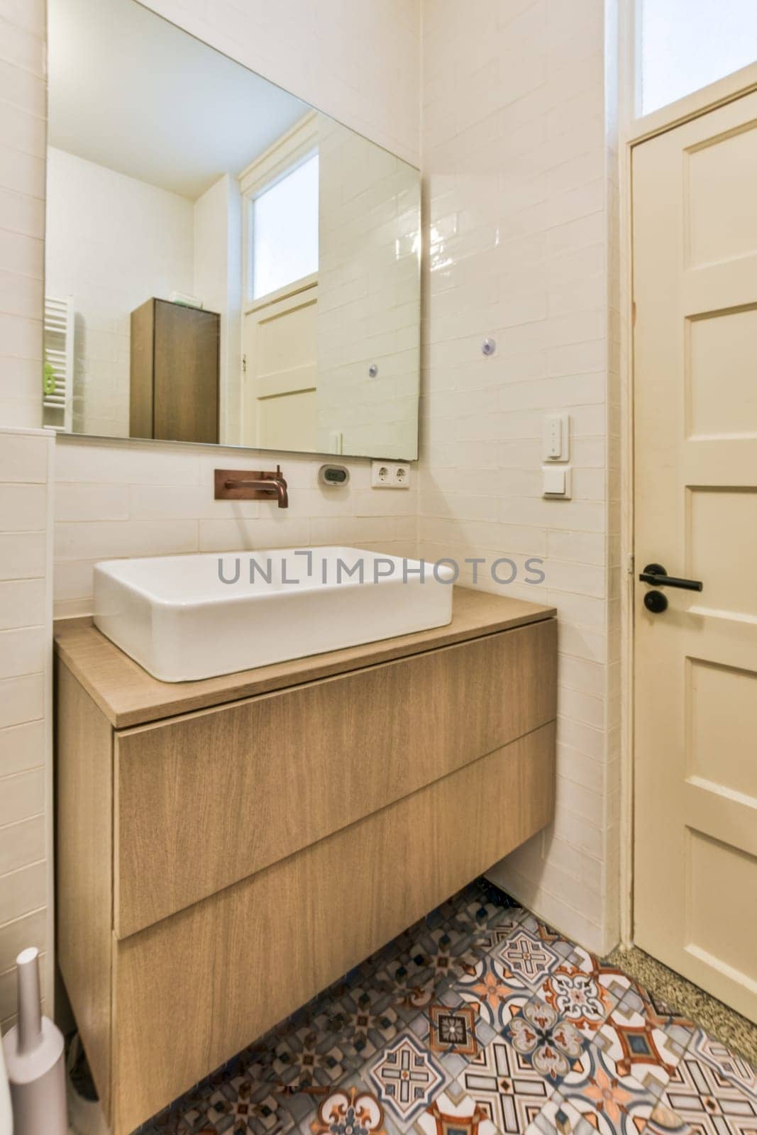 a bathroom with a sink, mirror and toilet paper on the floor in front of the door to the room