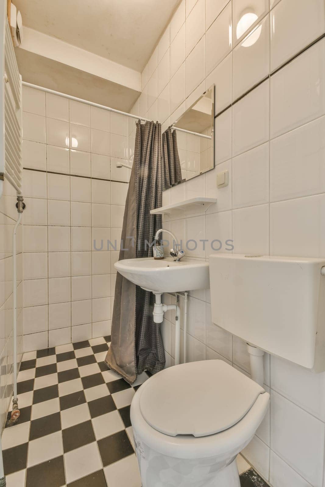 a bathroom with black and white checkered tiles on the floor, sink, toilet, and shower in it