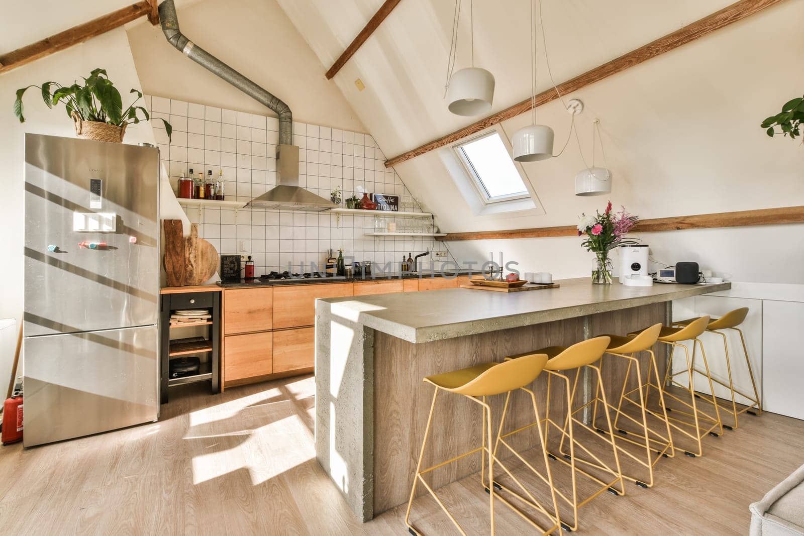 a kitchen with wooden flooring and white tiles on the walls, two yellow stools are in front of the counter