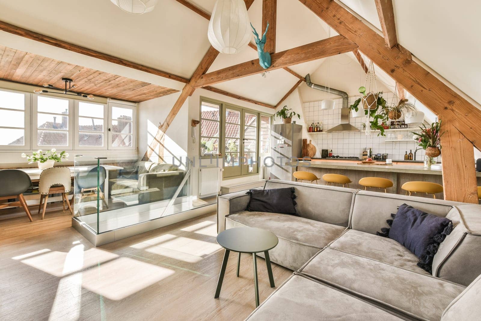 a living room with couches, tables and an open kitchen area in the corner of the room is shown