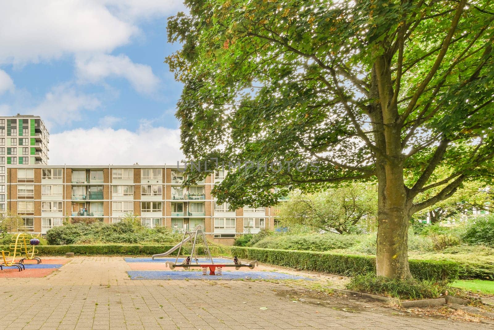 an apartment complex with playgrounds and play areas in the foreground area, near to london's hyde park