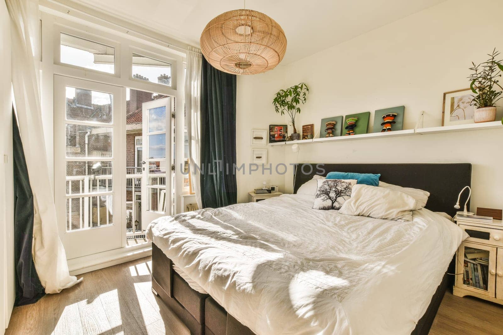 a bedroom with a bed, window, and door leading to the balcony area in the room is bright white