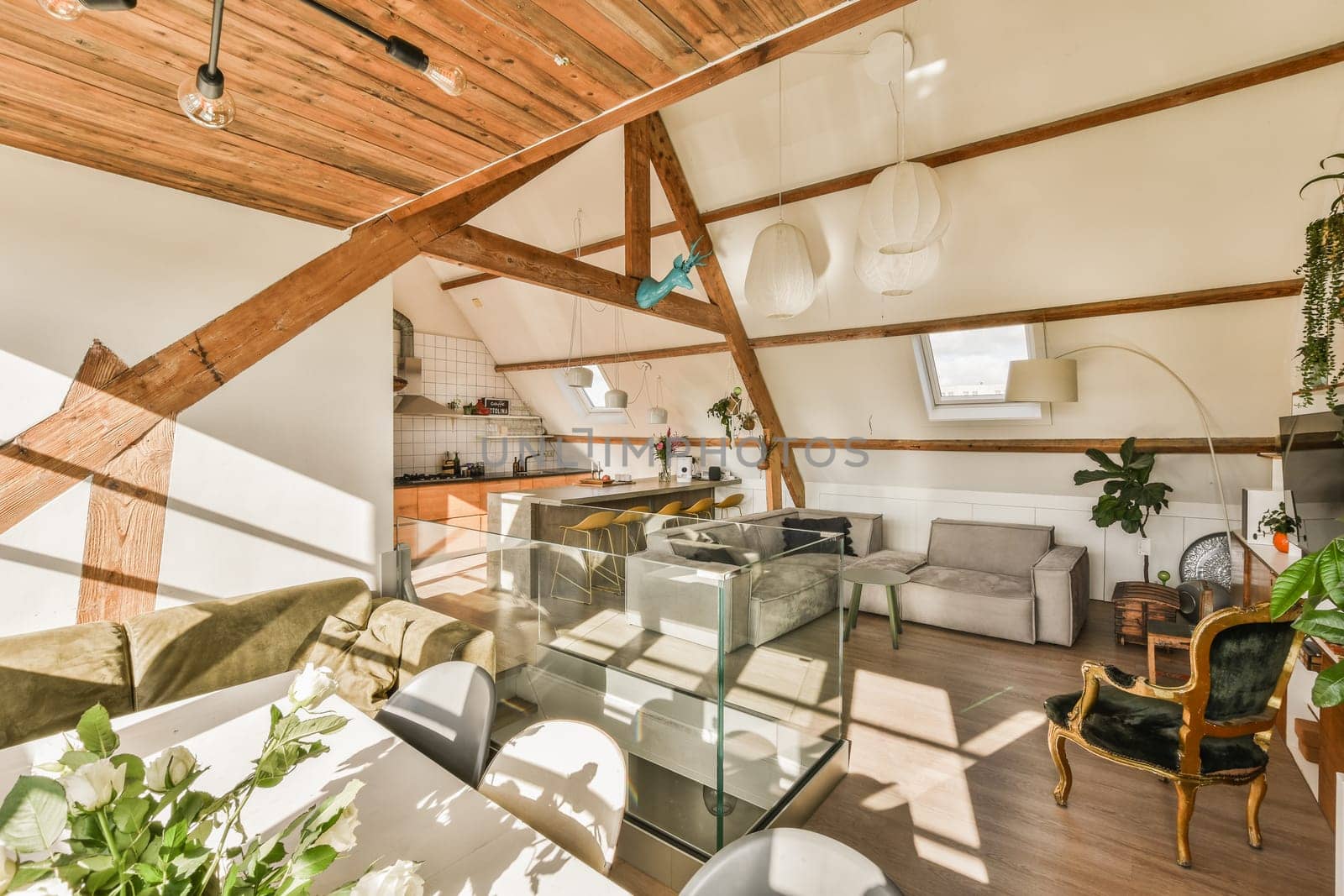 a living room with wood beams and white walls, including a glass coffee table in the center of the room