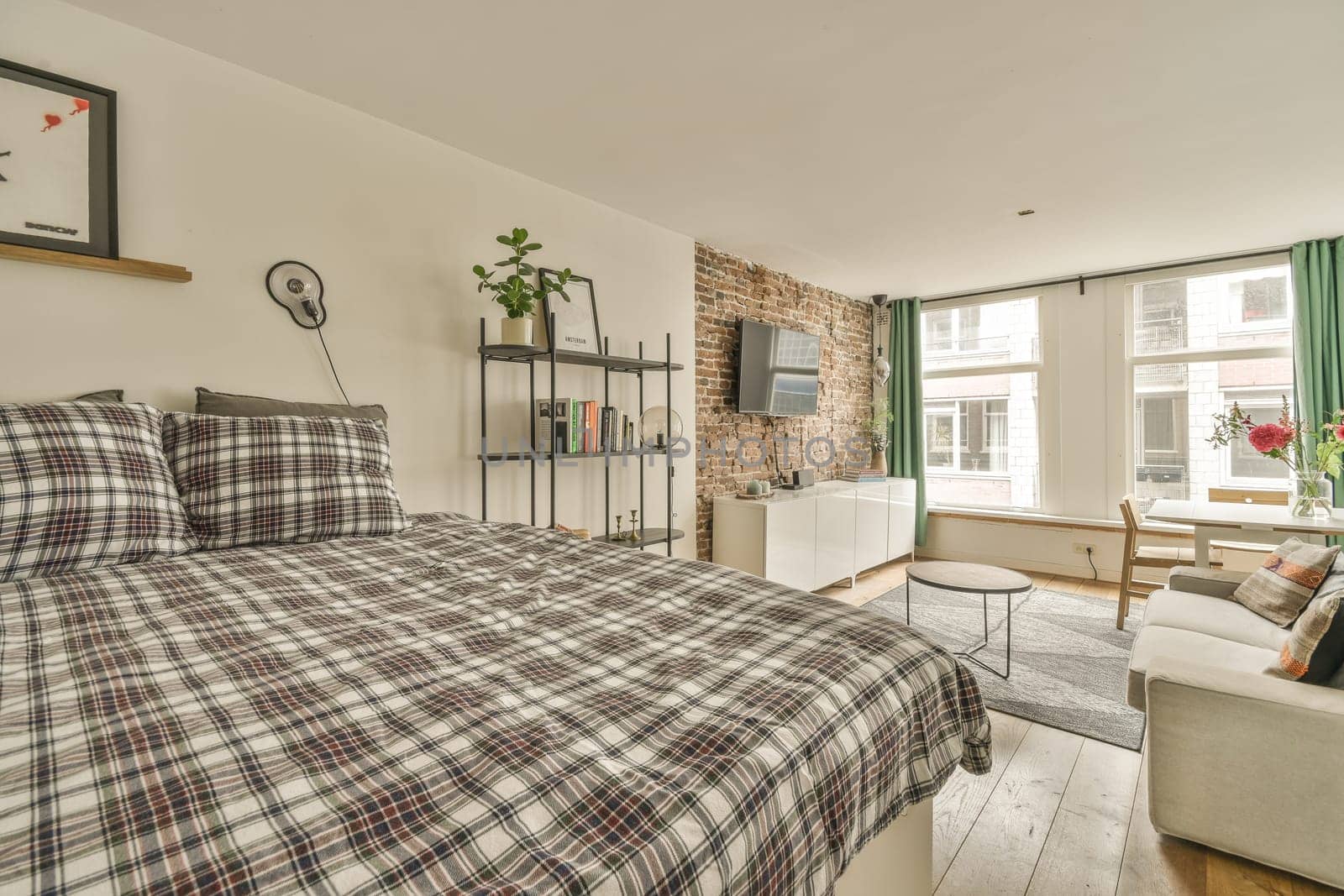 a bedroom with a bed, couch and tv on the wall in it's corner room next to an open window