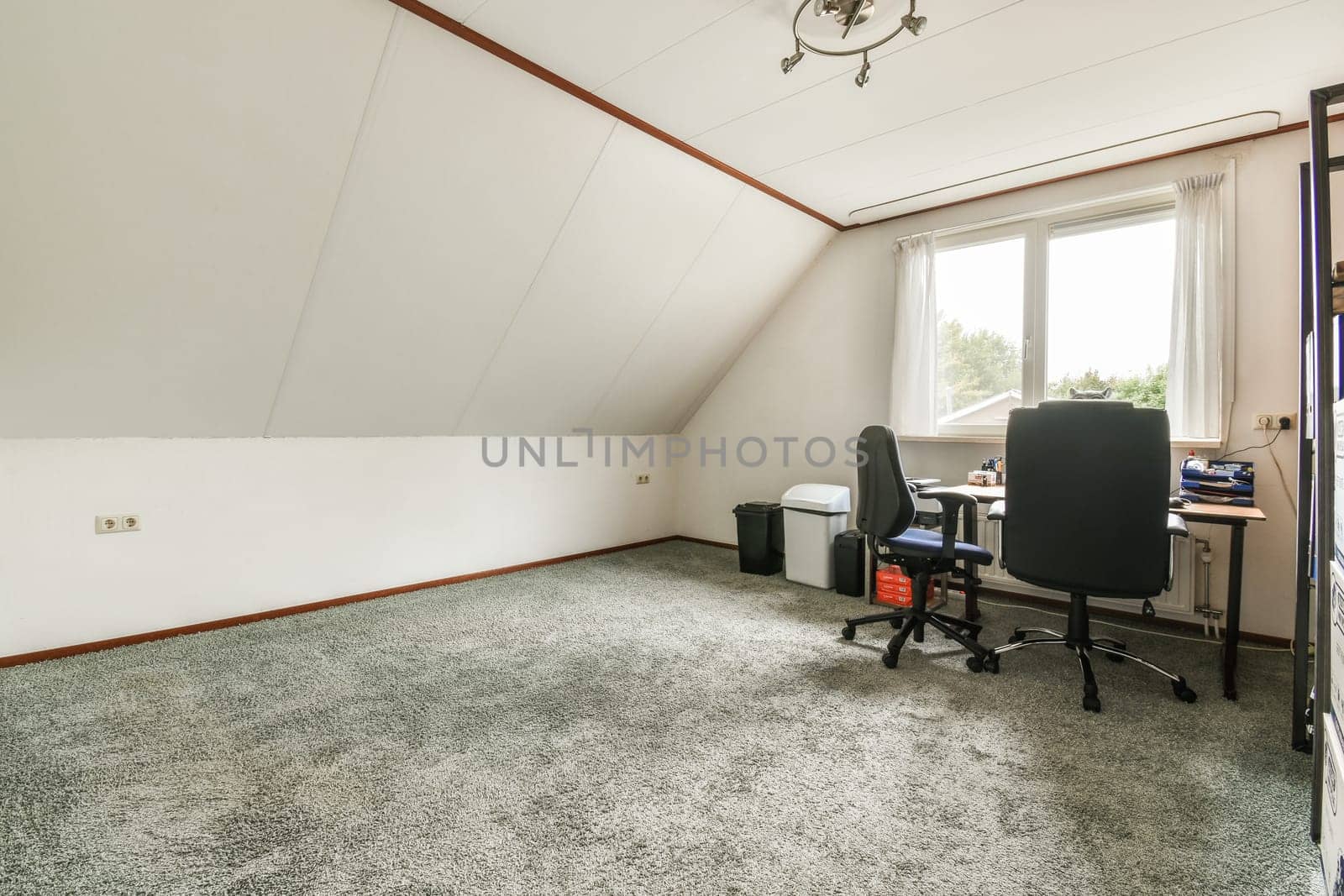 an empty room with a desk and computer on the floor in front of a window that looks out onto the street