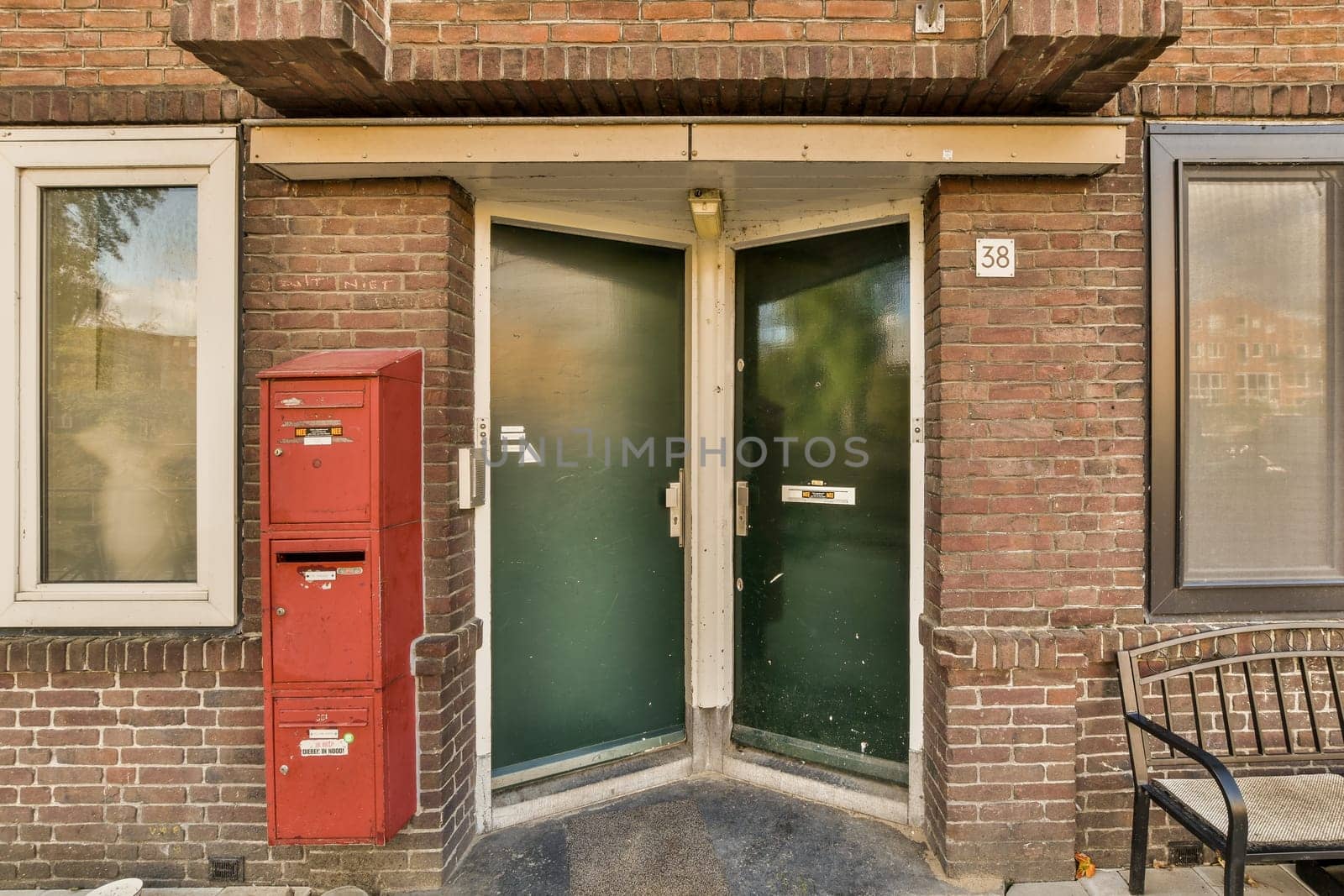 a brick building with a green door and red mailbox in the doorway is visible on the left side of the photo