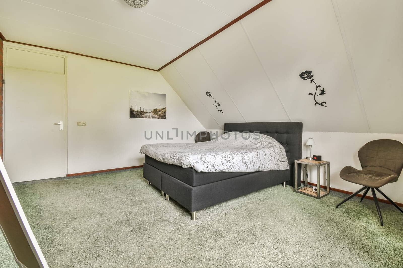 a bedroom with a bed, chair and desk in the corner next to the window on the left is an open door