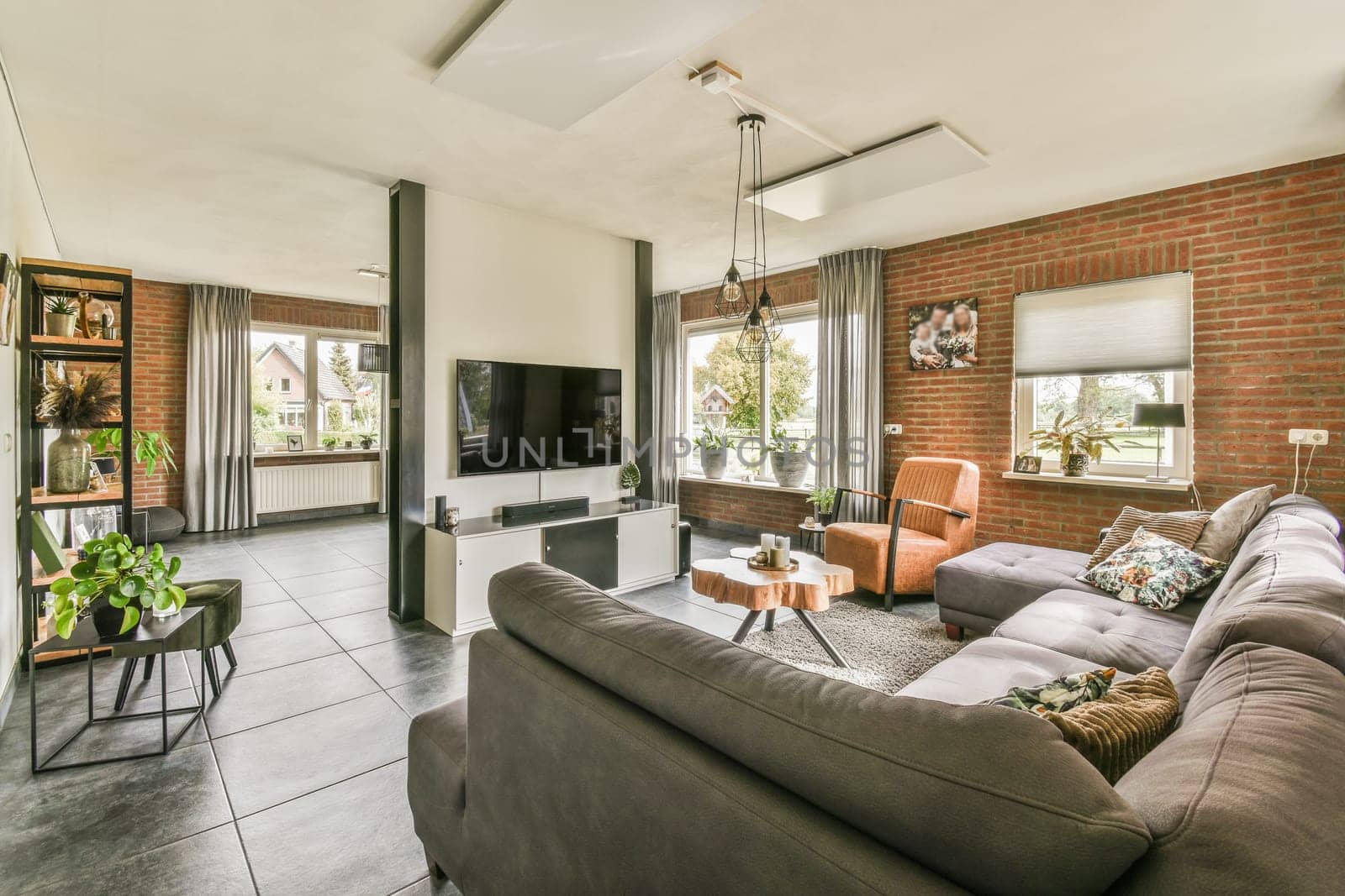 a living room with couches, chairs and a television in the middle of the room on the right side