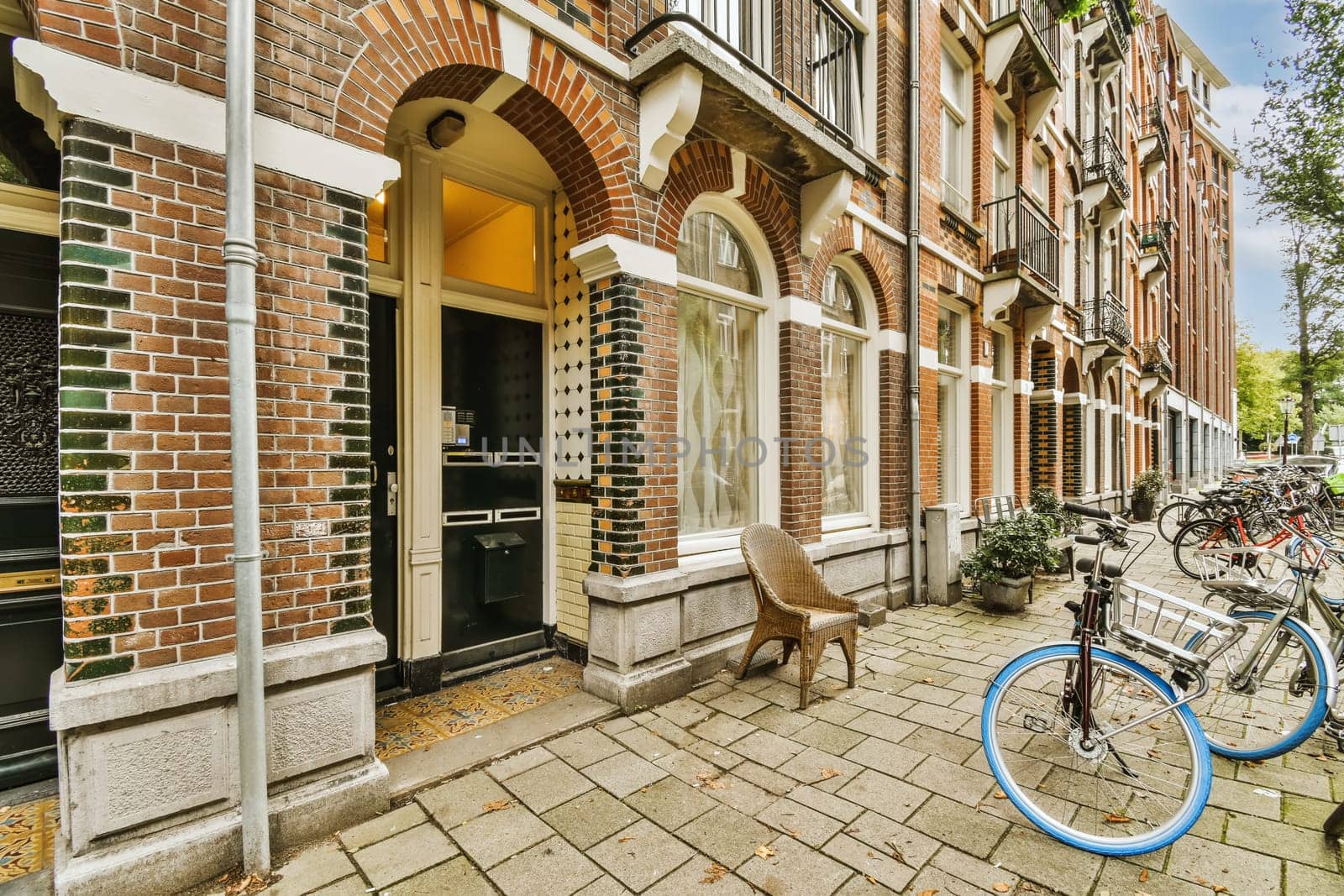 a bicycle parked in front of a brick building on a sidewalk with two bikes leaning against each other buildings behind it