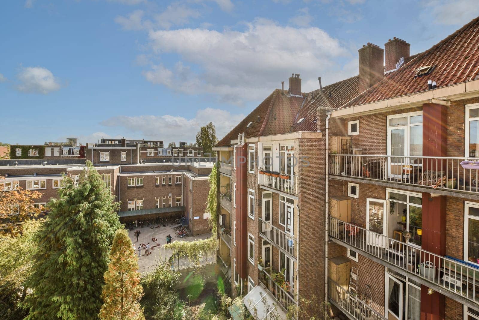 some buildings with balks on the top and trees in the bottom right hand corner, looking down to the street below