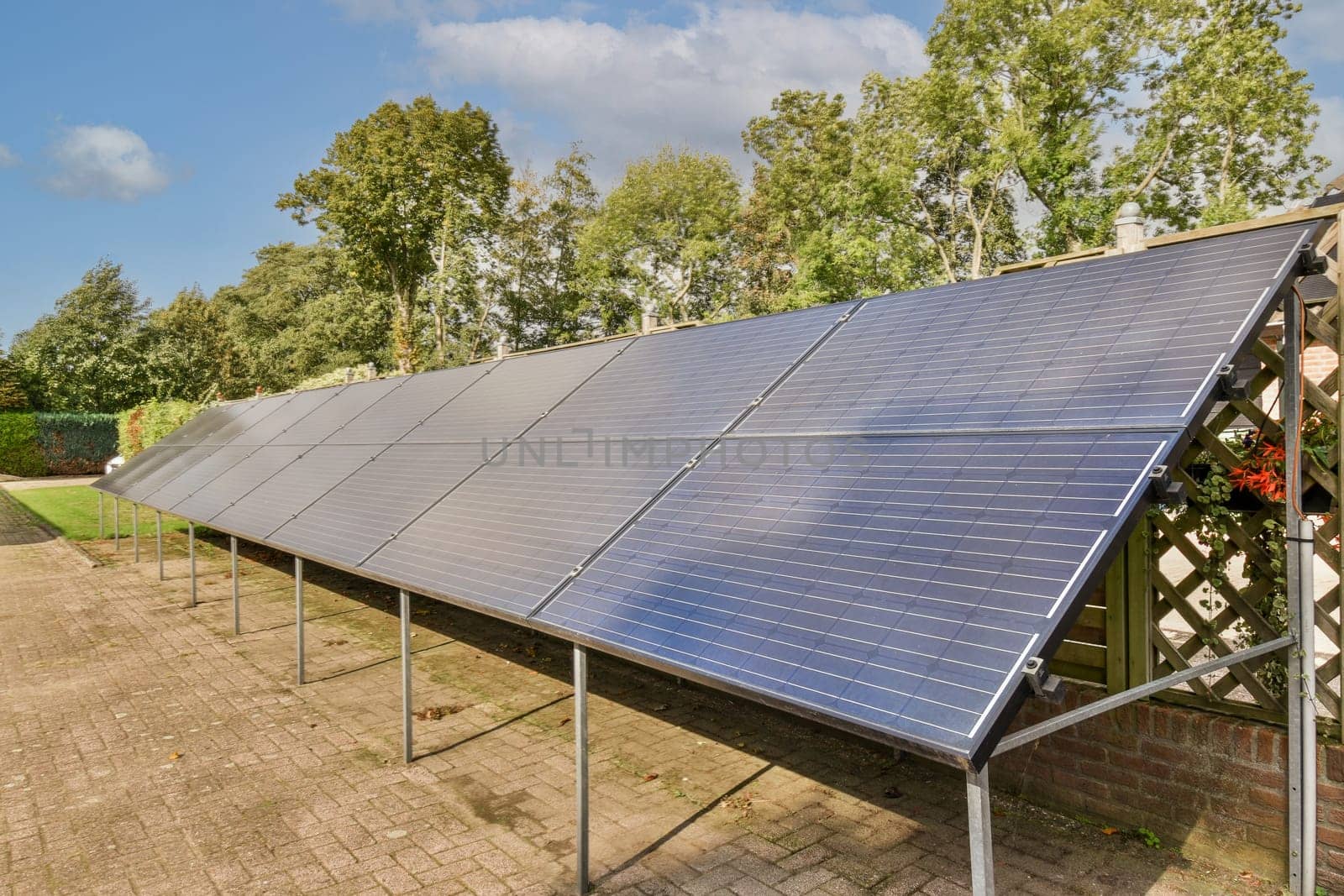 solar panels on the roof of a house with blue sky and white clouds in the photo is taken from behind