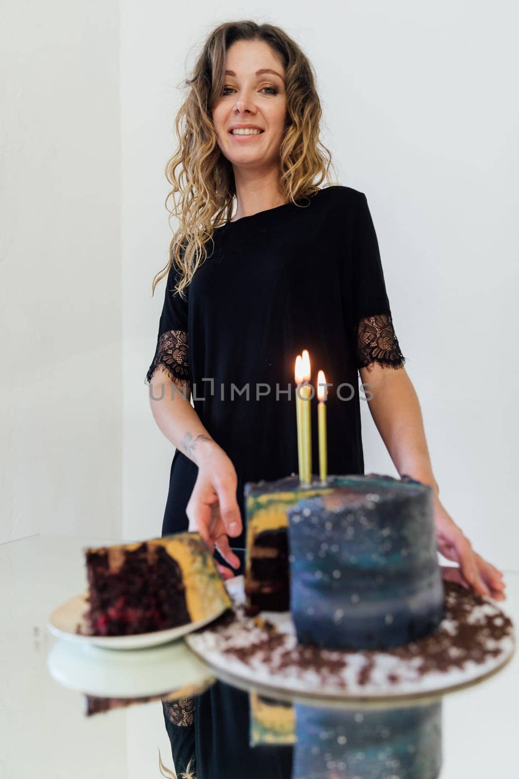 Beautiful woman cutting birthday cake and smiling