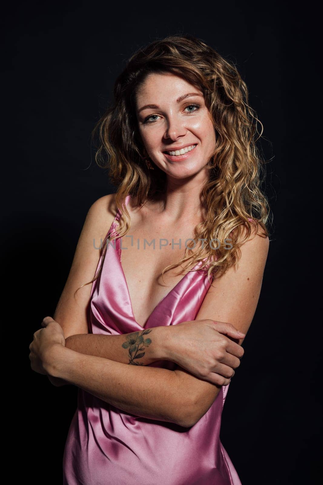 Beautiful slender woman in pink silk dress smiling