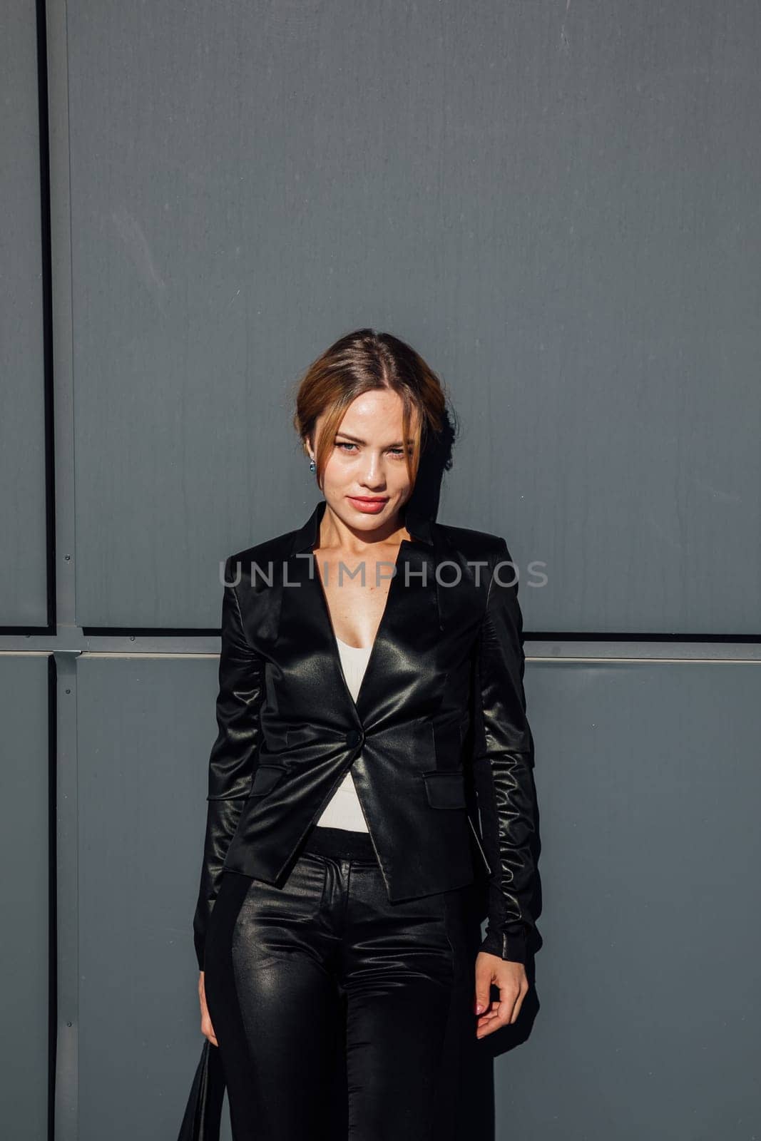 Portrait of a beautiful woman with a short hairstyle in a black fashion suit