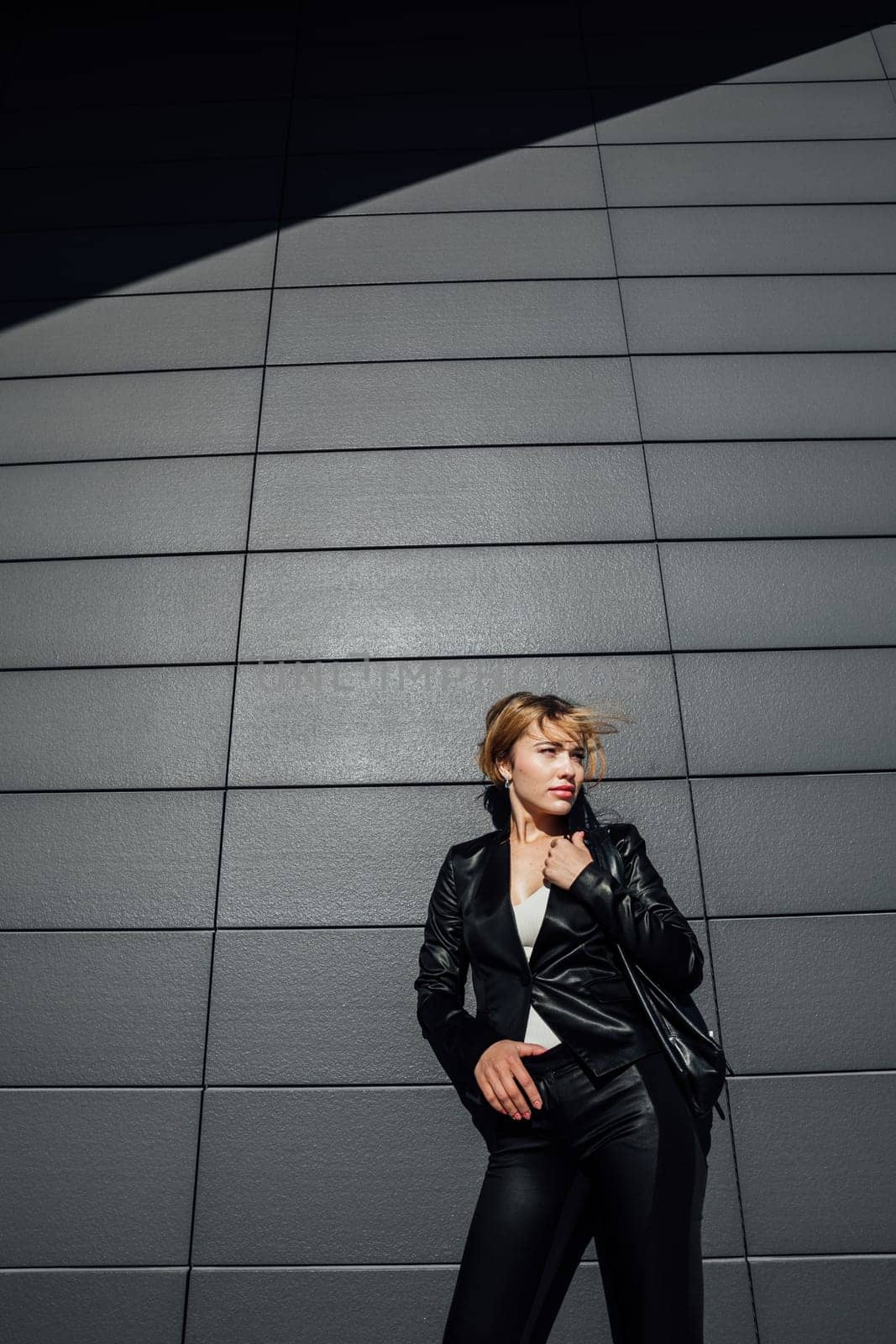 Portrait of a beautiful woman with a short hairstyle in a black fashion suit