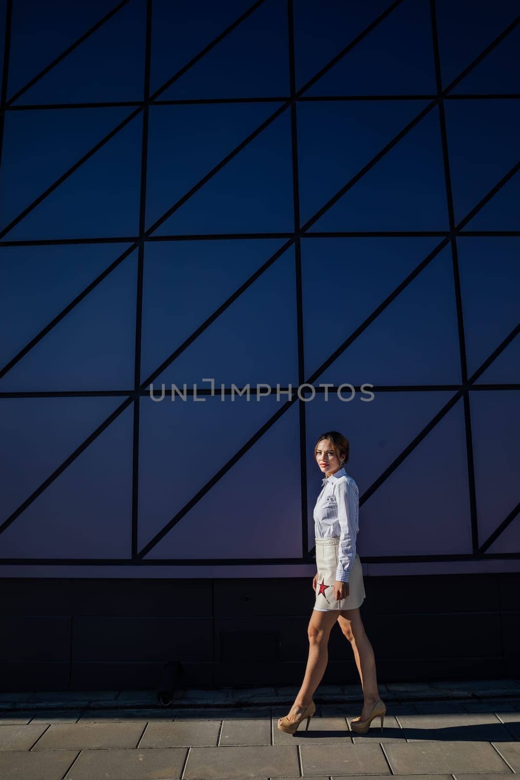 Portrait of a beautiful slender woman fashionably walking on the street