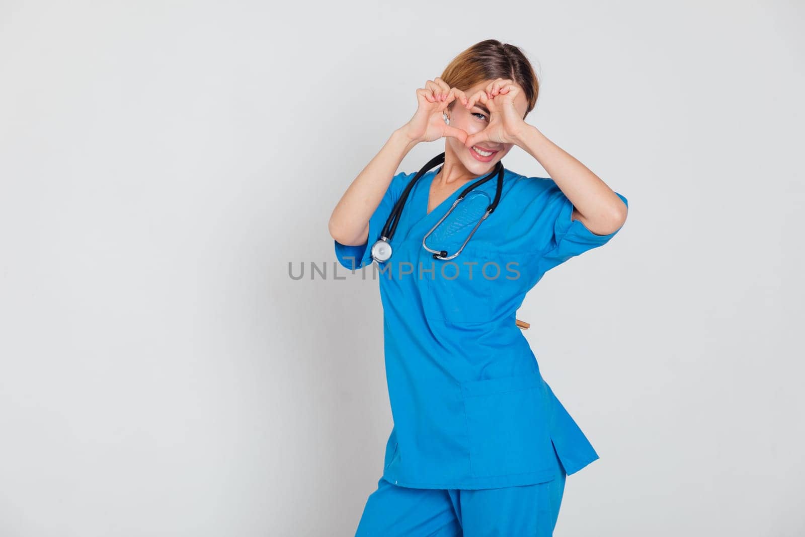 Beautiful Woman Doctor With Stethoscope In Hospital Showing Hand Heart