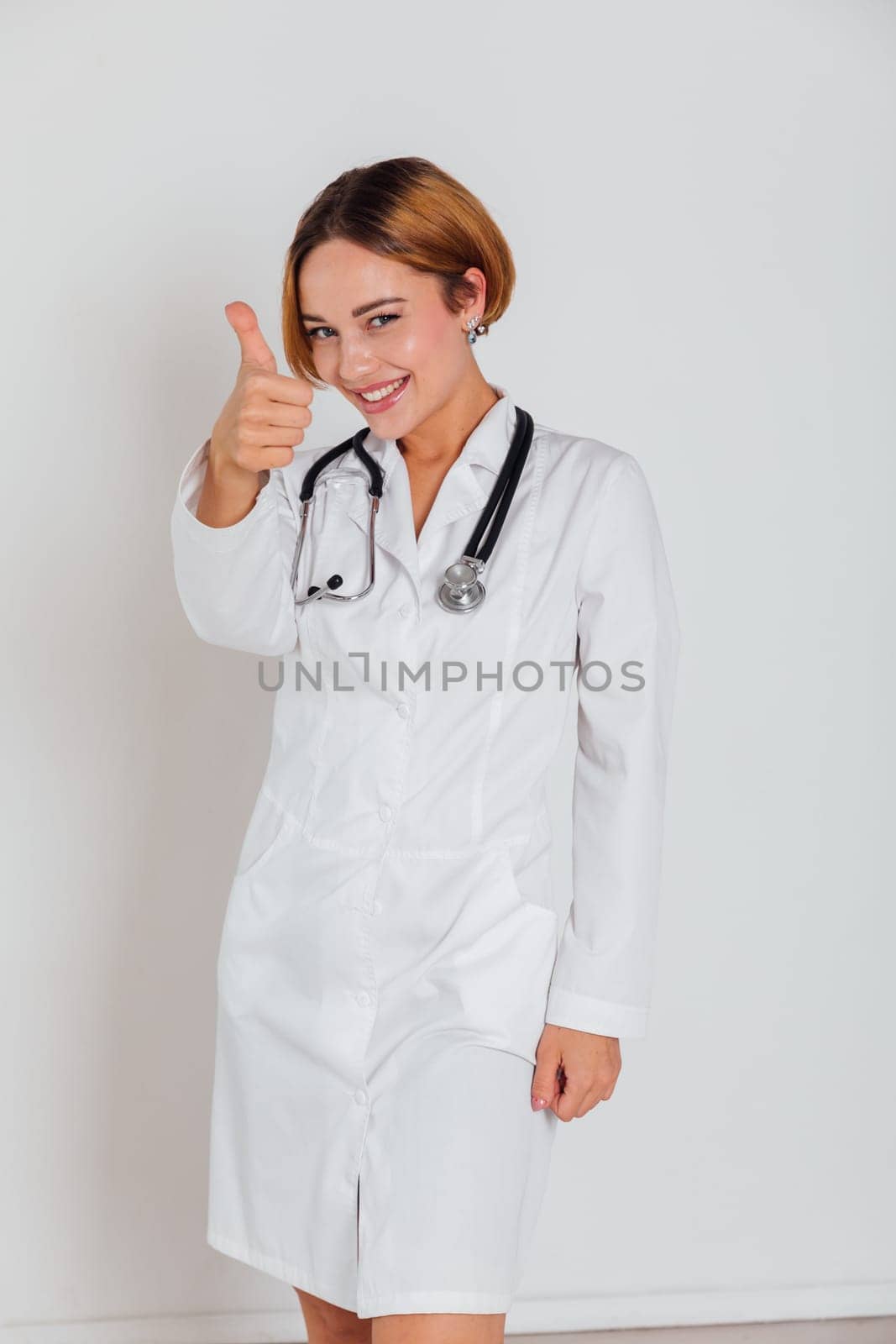 Beautiful Woman Doctor With Stethoscope In Hospital Showing Hand Thumbs Up