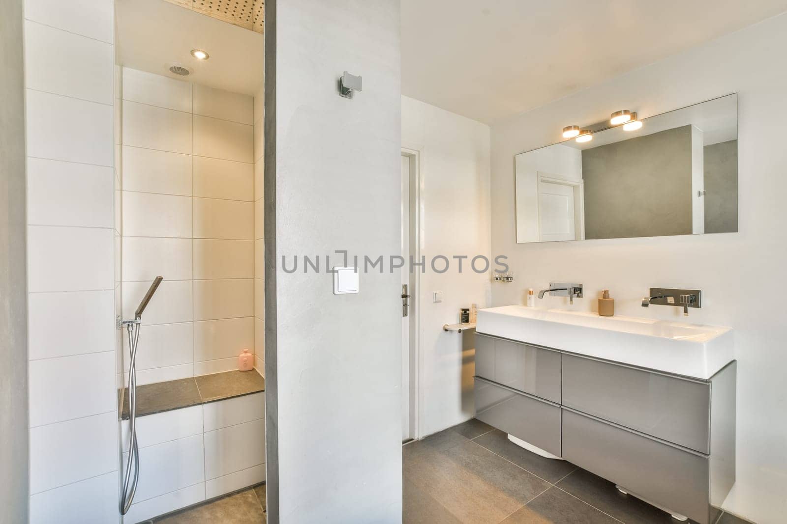 Contemporary bathroom featuring a sleek shower area and stylish vanity, complemented by elegant lighting and minimalistic decor for a serene atmosphere.