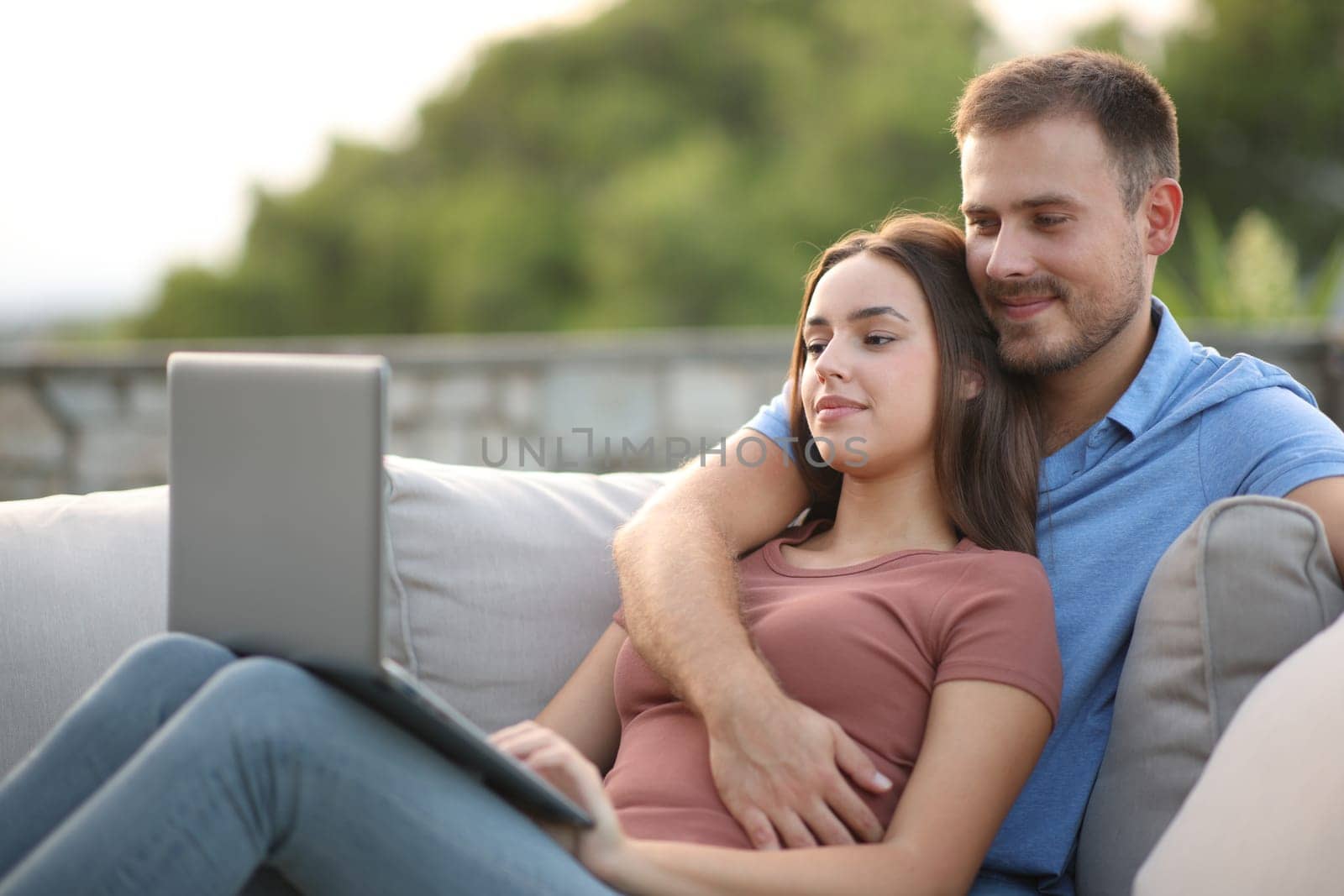 Couple checking laptop in a terrace